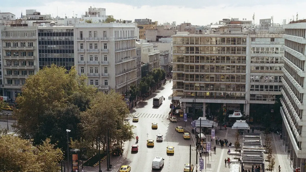 Κεντρικός δρόμος της Αθήνας με πολυκατοικίες και καταστήματα στα ισόγεια