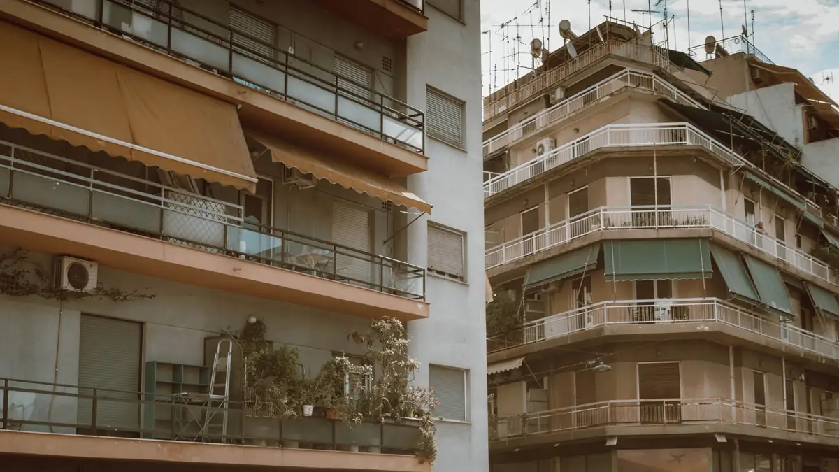 Προσόψεις πολυκατοικιών στην Αθήνα με τέντες και κλιματιστικά